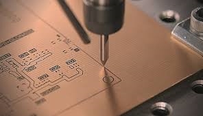 Close-up of CNC machinery milling traces on FR-4 substrate for construction sensor board