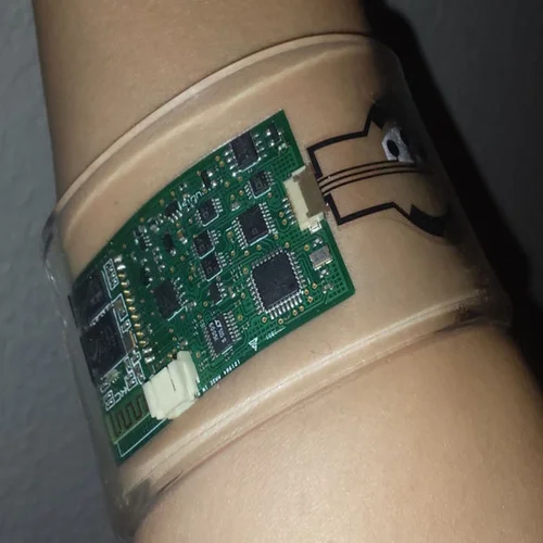 Prototype photo of a flexible wristband health monitor disassembled to show rigid-flex PCB with integrated sensors and HDI components