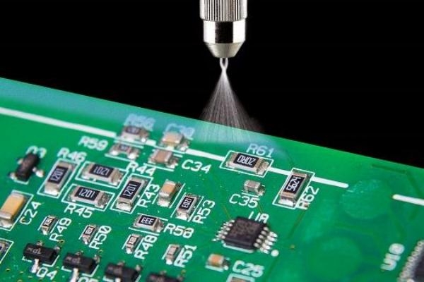 Automated machine applying conformal coating to a PCB assembly