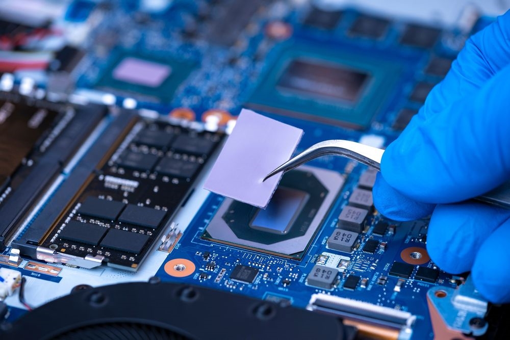 Engineer installing a thermal pad on a power supply component