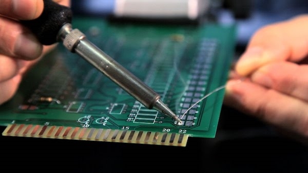 Engineer soldering small resistors on a prototype PCB