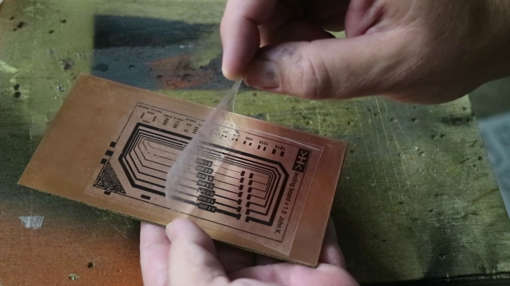 Ironing a toner-printed design onto a copper-clad PCB for etching