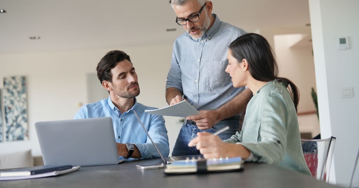 Team discussing PCB project budget with cost charts on a table