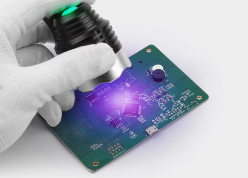PCB under UV light for solder mask curing process